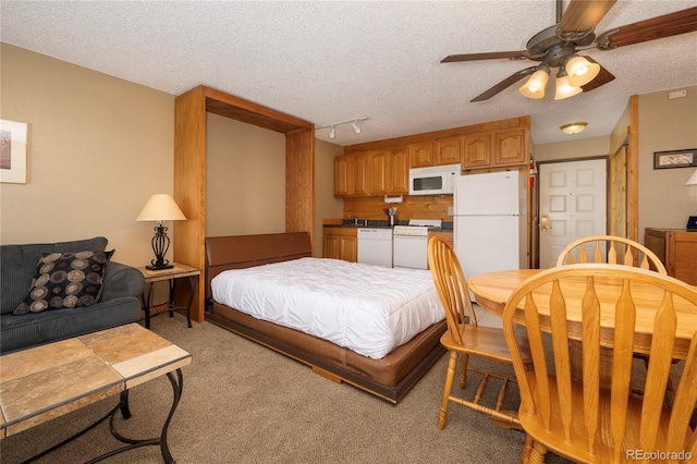 bedroom featuring a textured ceiling, ceiling fan, light colored carpet, freestanding refrigerator, and rail lighting