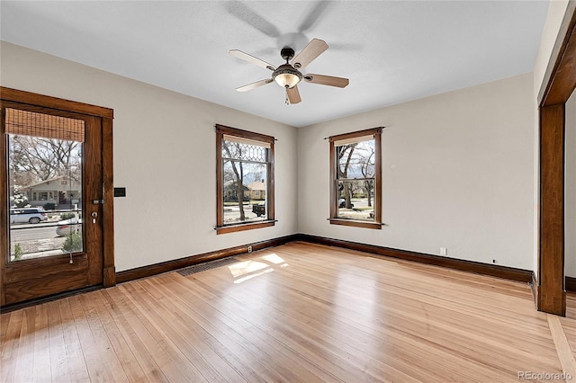 unfurnished room with ceiling fan, baseboards, and light wood-style floors
