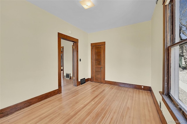 spare room featuring baseboards and wood finished floors