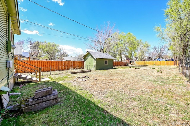 view of yard featuring a storage shed, an outbuilding, and a fenced backyard