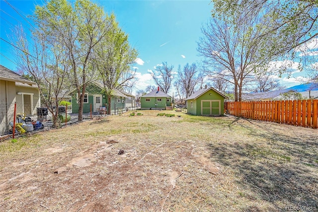 view of yard with a fenced backyard, an outdoor structure, and a shed