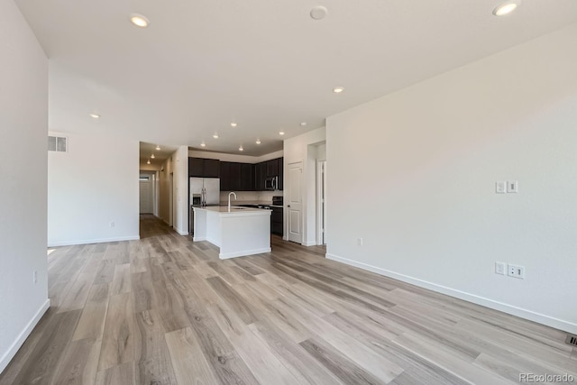 unfurnished living room featuring light hardwood / wood-style flooring and sink