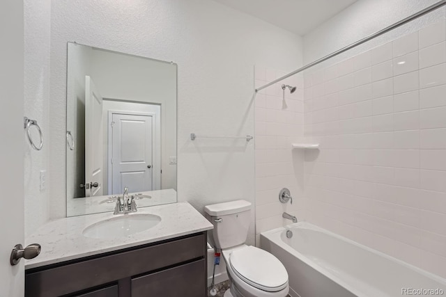 full bathroom with vanity, tiled shower / bath combo, and toilet