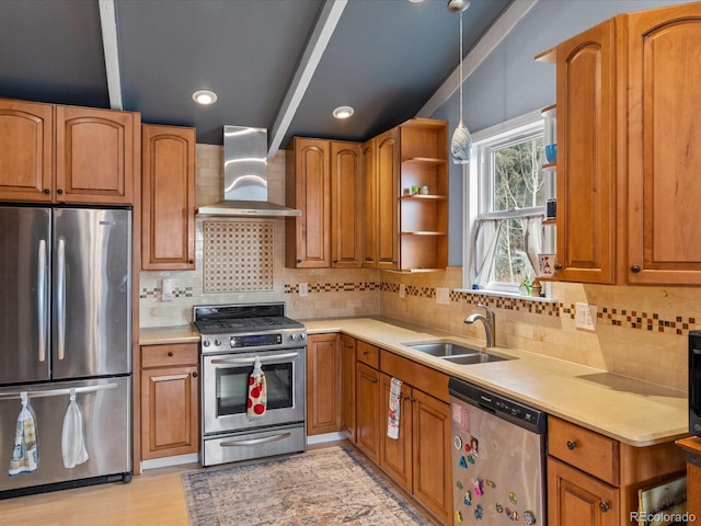 kitchen with stainless steel appliances, sink, wall chimney range hood, decorative backsplash, and pendant lighting