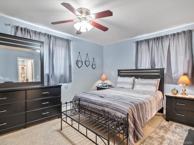 carpeted bedroom featuring a textured ceiling and ceiling fan