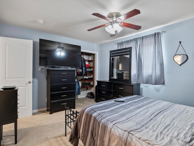 bedroom with ceiling fan, a textured ceiling, and light colored carpet