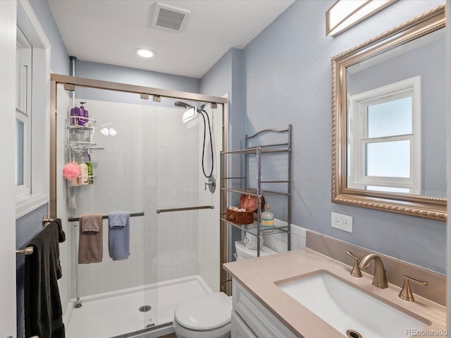 bathroom with toilet, vanity, and an enclosed shower