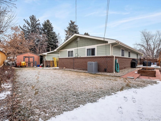 snow covered property featuring a storage shed