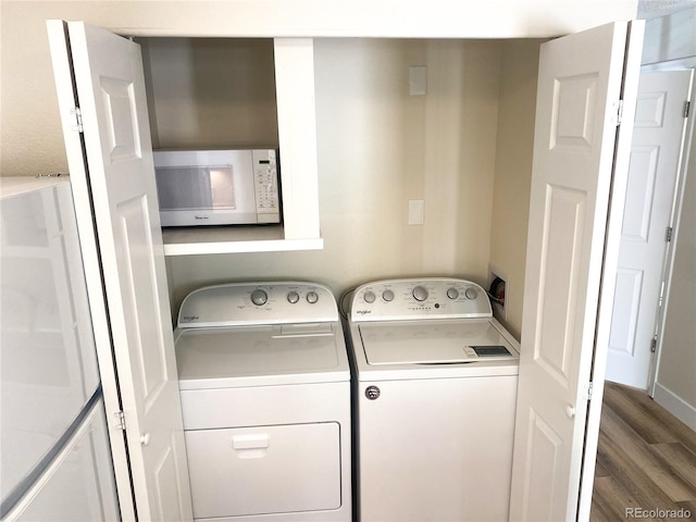 washroom featuring dark wood-type flooring and washing machine and clothes dryer