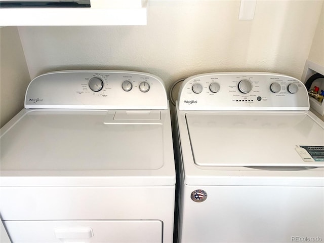 clothes washing area with washer and clothes dryer