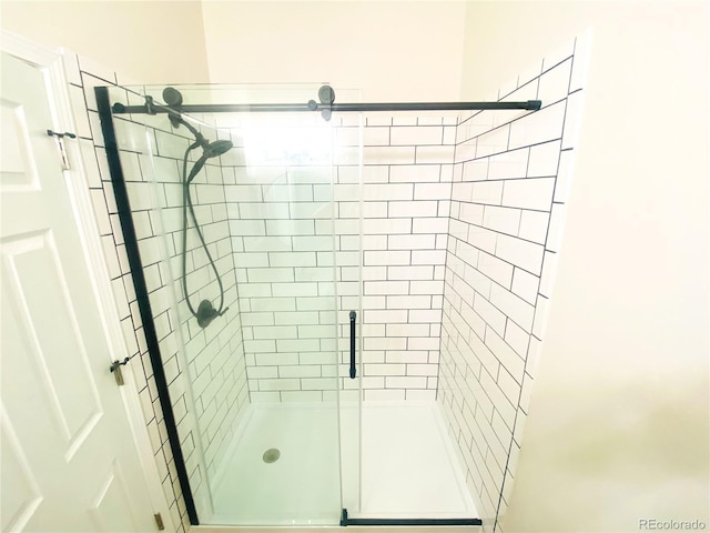 bathroom with a shower with door