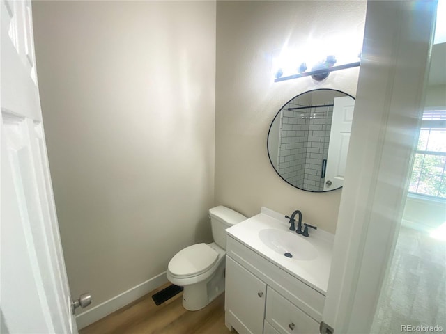 bathroom with hardwood / wood-style flooring, toilet, and vanity