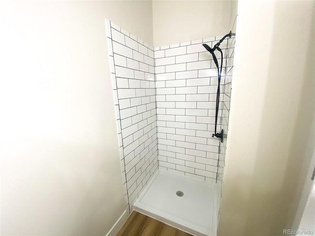 bathroom featuring wood-type flooring and tiled shower