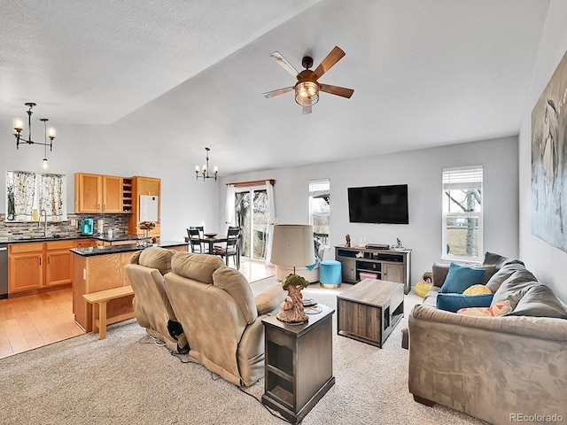 living room with vaulted ceiling, ceiling fan with notable chandelier, and a textured ceiling