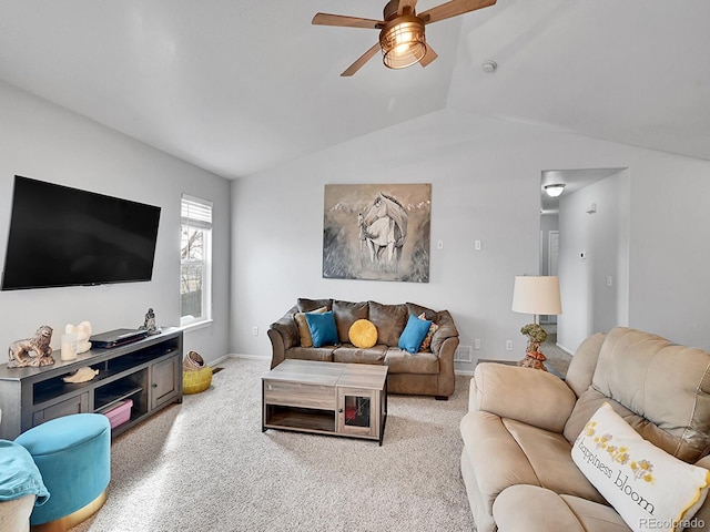 living area with baseboards, lofted ceiling, and ceiling fan