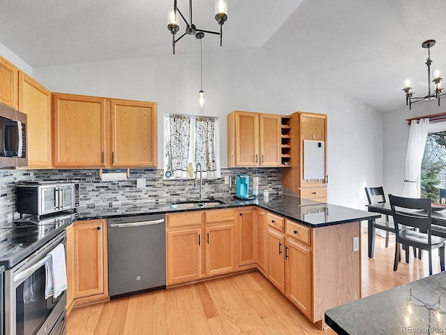 kitchen with a notable chandelier, a sink, stainless steel appliances, a peninsula, and lofted ceiling