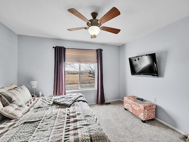 carpeted bedroom with ceiling fan and baseboards