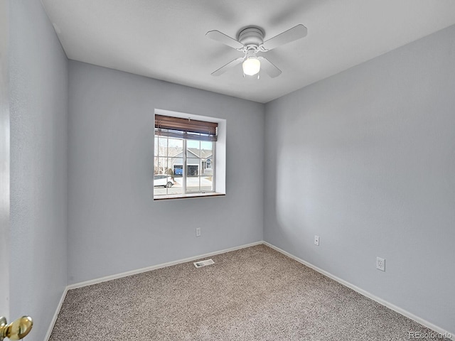 spare room featuring a ceiling fan, visible vents, carpet floors, and baseboards