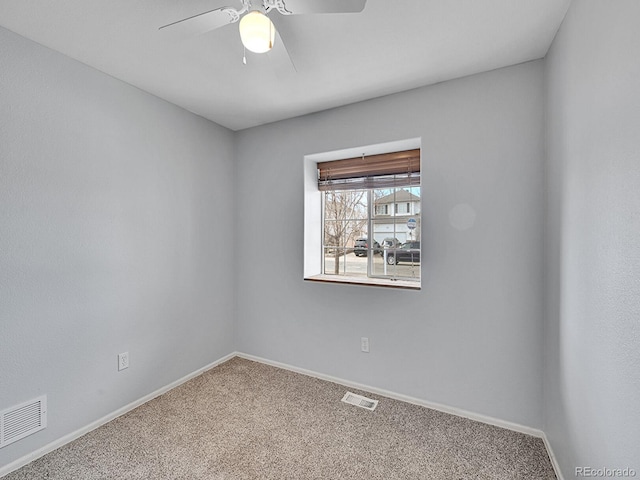 spare room featuring visible vents, carpet flooring, baseboards, and ceiling fan