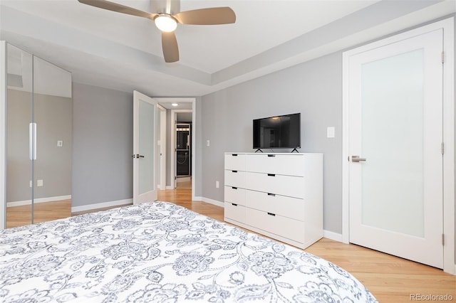 bedroom featuring light wood finished floors, a ceiling fan, and baseboards