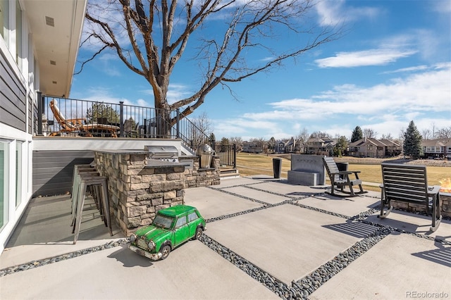 view of patio / terrace with exterior kitchen, a residential view, and grilling area