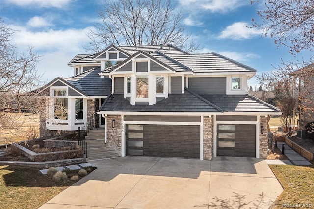 view of front of house featuring concrete driveway, a garage, and stone siding