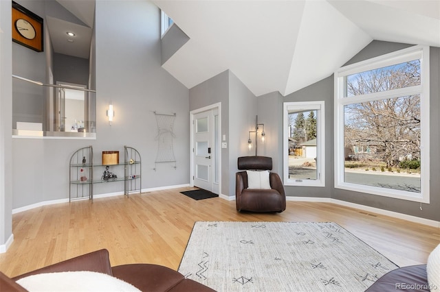 sitting room featuring baseboards, high vaulted ceiling, and wood finished floors