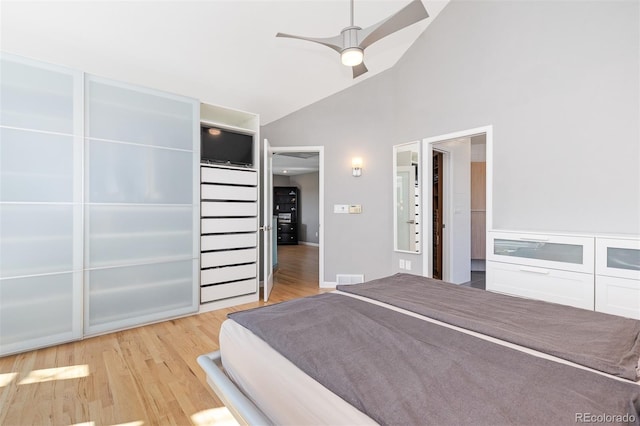 bedroom featuring a ceiling fan, wood finished floors, visible vents, and high vaulted ceiling