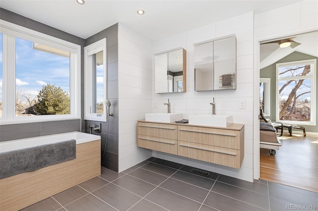 full bathroom with a sink, a healthy amount of sunlight, and tile patterned floors