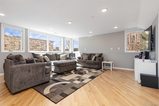 living room featuring recessed lighting, baseboards, and light wood finished floors