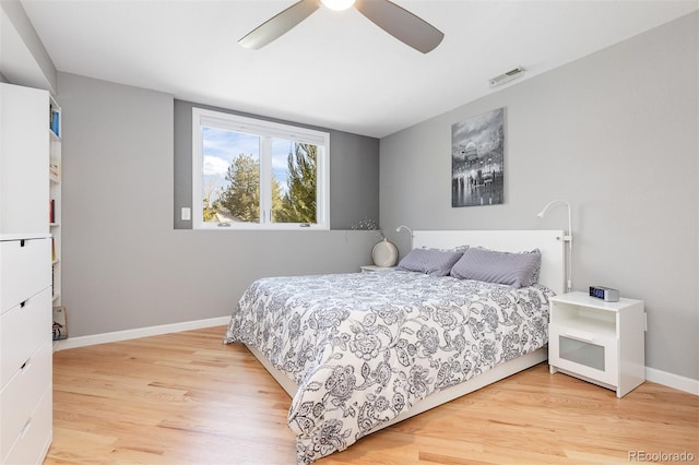 bedroom with ceiling fan, visible vents, baseboards, and light wood-style flooring