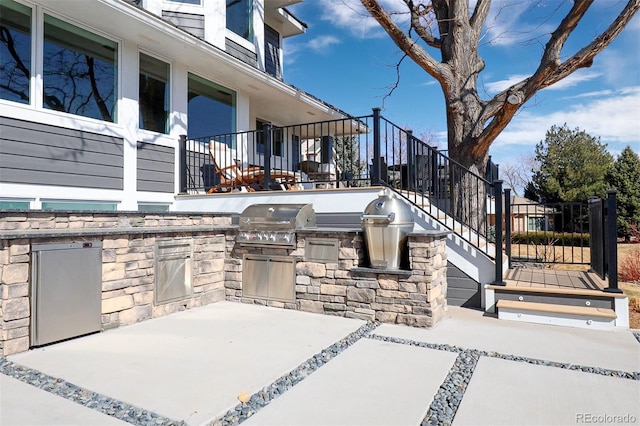 view of patio with a grill, an outdoor kitchen, and stairs