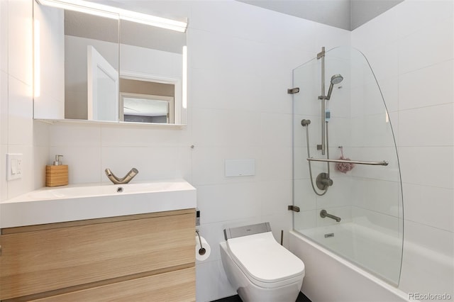 bathroom featuring vanity, tile walls, toilet, and shower / washtub combination