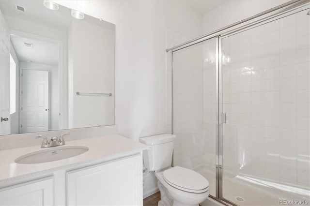 bathroom featuring vanity, toilet, and an enclosed shower