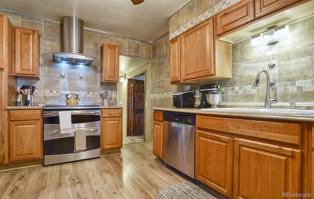 693 E Ave, Limon, CO 80828 - kitchen featuring a sink, backsplash, stainless steel appliances, and wall chimney exhaust hood