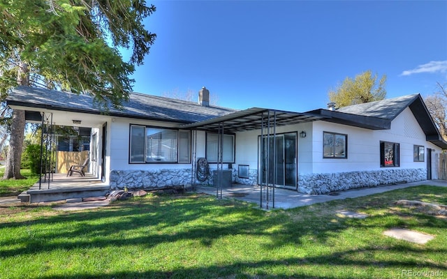 693 E Ave, Limon, CO 80828 - rear view of house with a yard, stone siding, a chimney, and a patio area