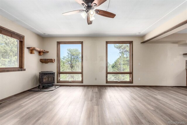 116 Schooley Rd, Bailey, CO 80421 - unfurnished living room with a wood stove, healthy amount of natural light, and wood finished floors