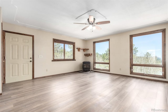 116 Schooley Rd, Bailey, CO 80421 - unfurnished living room with a wood stove, ceiling fan, and light wood finished floors