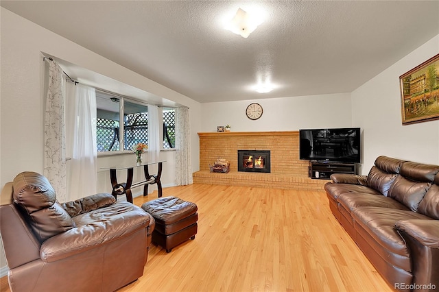 7439 S Depew St, Littleton, CO 80128 - living area with light wood-type flooring, a fireplace, and a textured ceiling