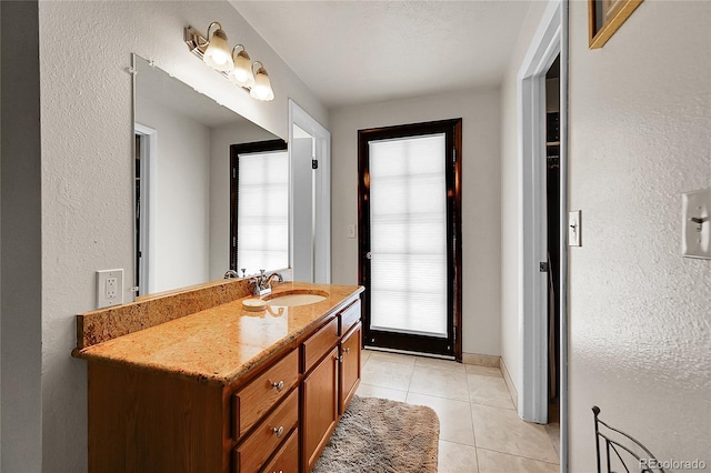 7439 S Depew St, Littleton, CO 80128 - bathroom featuring vanity, tile patterned flooring, and a textured wall