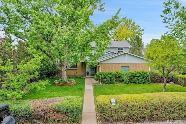 7439 S Depew St, Littleton, CO 80128 - obstructed view of property featuring brick siding and a front yard