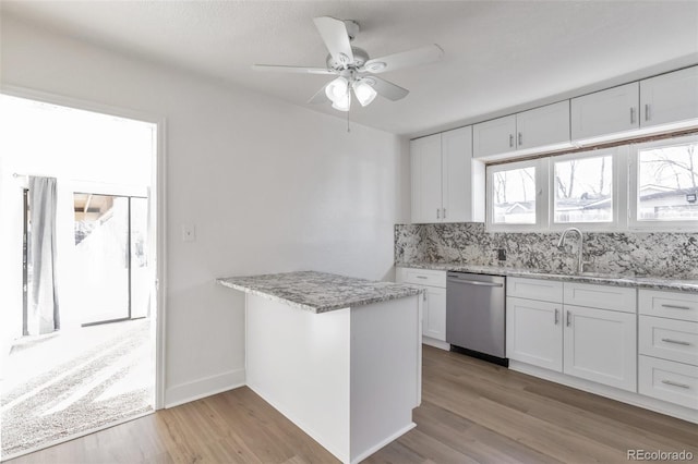 kitchen featuring sink, white cabinetry, decorative backsplash, stainless steel dishwasher, and light wood-type flooring