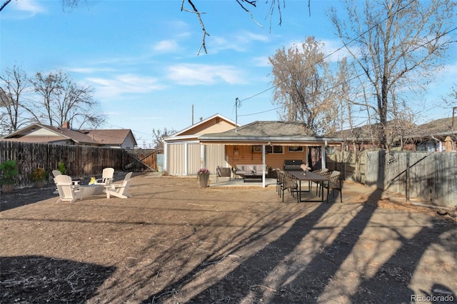 back of property featuring a patio area and an outdoor living space with a fire pit