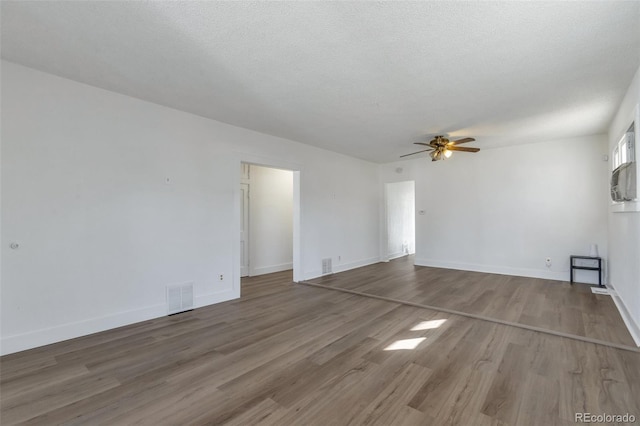 unfurnished living room with ceiling fan, wood-type flooring, and a textured ceiling