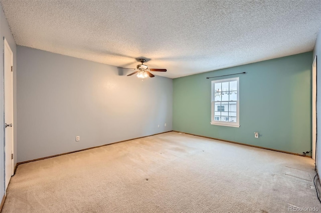 spare room featuring ceiling fan, a textured ceiling, and light carpet