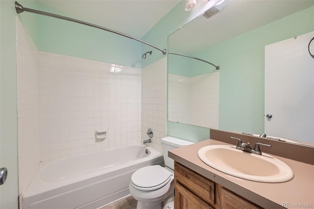 full bathroom featuring vanity, tiled shower / bath combo, and toilet