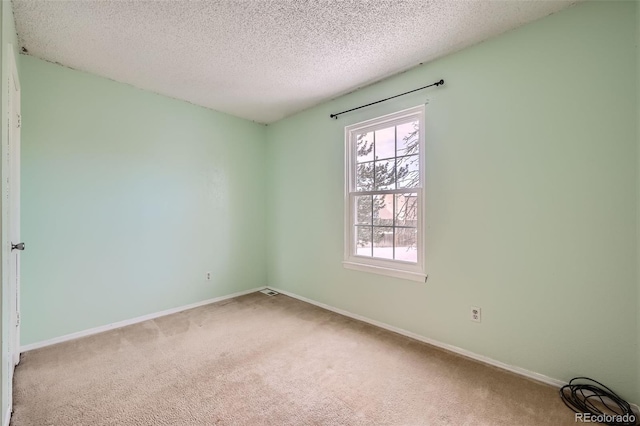 unfurnished room featuring carpet flooring and a textured ceiling