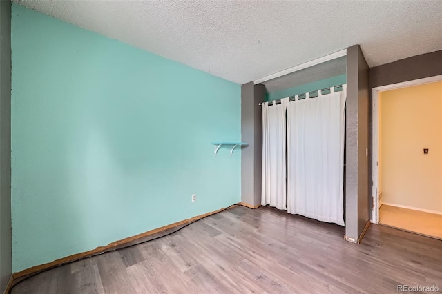 unfurnished bedroom featuring hardwood / wood-style floors and a textured ceiling