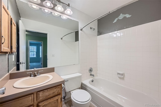 full bathroom with vanity, tiled shower / bath combo, and toilet