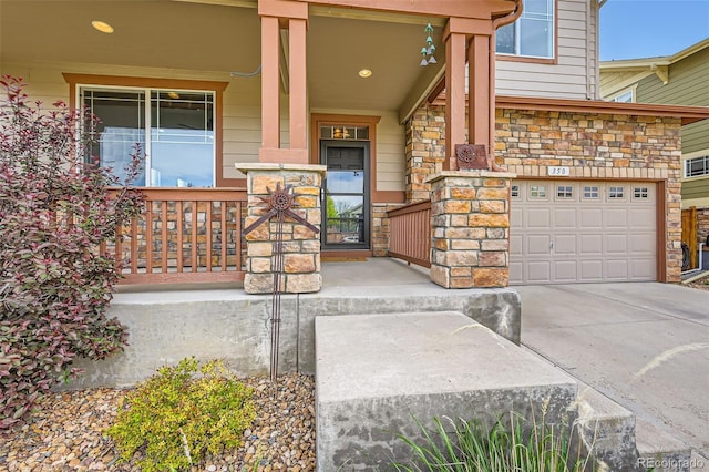 350 N Langdale Ct, Aurora, CO 80018 - view of exterior entry featuring a porch, stone siding, driveway, and an attached garage